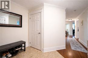 Hamilton condo for rent - A hallway with a white door and a bench with shoes on it.