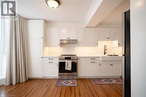 Hamilton condo for rent - A kitchen with white cabinets and a wooden floor.