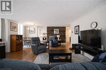 Hamilton condo for rent - A living room with a grey couch and a wooden floor.
