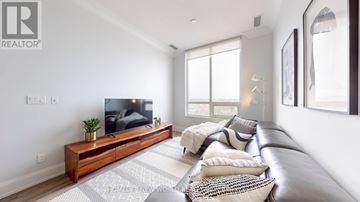 Markham (Unionville) condo for rent - A living room with a large couch and a flat screen TV.