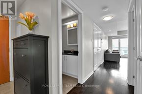 Ottawa condo for rent - A modern kitchen with a black cabinet and a vase of flowers on top.