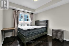 Ottawa condo for rent - A bedroom with a large bed, a window with curtains, and a wooden nightstand.