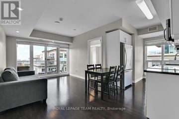 Ottawa condo for rent - A well-lit, spacious living room with a grey sofa and a dining table set for four.