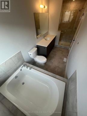 Pickering townhouse for rent - A bathroom with a tub, toilet, and sink.