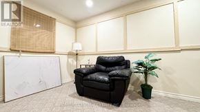 Markham (Aileen-Willowbrook) apartment for rent - A black leather chair sits in a room with a white wall and a plant.