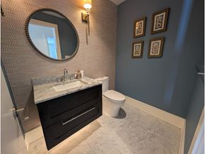 White Rock apartment for rent - A bathroom with a marble countertop and a round mirror.
