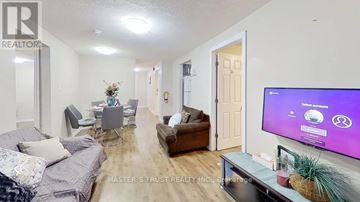 Waterloo condo for rent - A living room with a grey couch and a television on the right side.