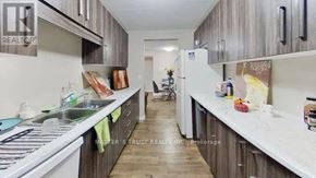 Waterloo condo for rent - A kitchen with wooden cabinets and a white countertop.