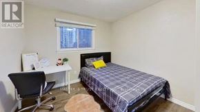 Waterloo condo for rent - A bedroom with a bed, desk, chair, and window.