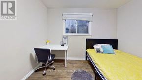 Waterloo condo for rent - A bedroom with a bed, desk, and chair.