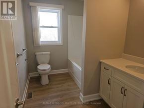 Mcnab/Braeside apartment for rent - A white toilet sits in a bathroom with a window above it.