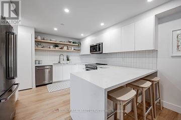 Toronto (Pleasant View) condo for rent - A modern kitchen with white cabinets and a white island.