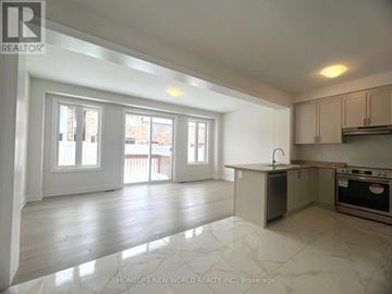 East Gwillimbury (Queensville) townhouse for rent - A spacious kitchen and living room with white cabinets and a marble floor.