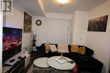 Oakville (Jm Joshua Meadows) condo for rent - A living room with a black couch and a flat screen TV.