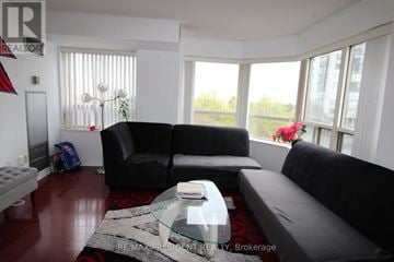 Mississauga (City Centre) condo for rent - A living room with a black couch and a glass coffee table.