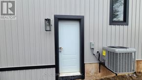 Welland (Welland Downtown) apartment for rent - A white door with a black frame is on a house with a Royal LePage sign on the wall.