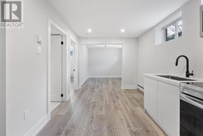 Welland (Welland Downtown) apartment for rent - A modern kitchen with white cabinets and a wooden floor.