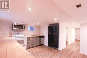 Toronto (Oakwood Village) apartment for rent - A kitchen with a white oven and a black refrigerator.