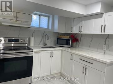 Toronto (Dorset Park) apartment for rent - A kitchen with white cabinets and a marble backsplash.