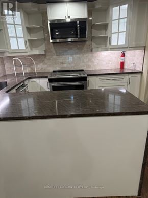 Richmond Hill (Westbrook) apartment for rent - A kitchen with white cabinets and a black counter top.