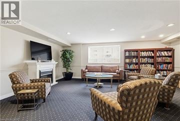 Burlington condo for rent - A living room with a fireplace and a bookshelf filled with books.