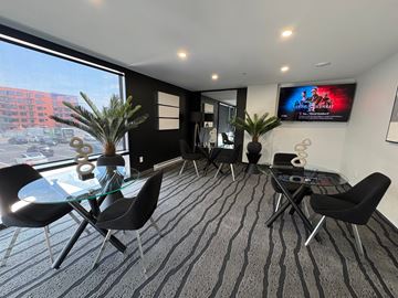 Moncton apartment for rent - A modern living room with a glass table and black chairs.
