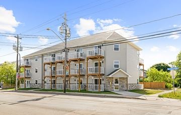 Moncton apartment for rent - A large apartment building with a balcony on the second floor.