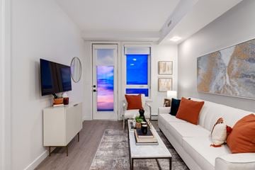 Calgary apartment for rent - A living room with a white couch and a television on the wall.