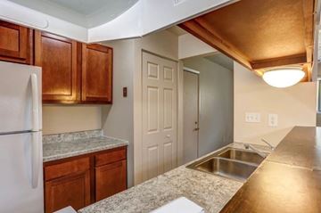 Plainwell apartment for rent - A kitchen with a white refrigerator and wooden cabinets.