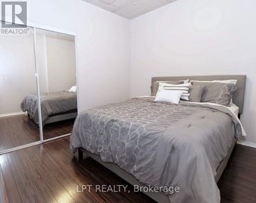 Toronto (Little Portugal) condo for rent - A bedroom with a large bed and a mirror on the wall.