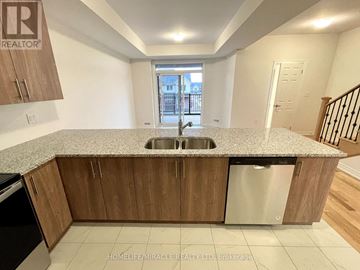 Oshawa (Windfields) townhouse for rent - A kitchen with wooden cabinets and a granite countertop.