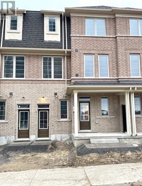 Oshawa (Windfields) townhouse for rent - A two-story brick building with a black roof and white trim.