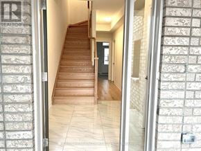 Oshawa (Windfields) townhouse for rent - A hallway with a staircase and a door on the left.