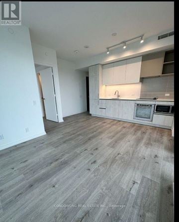 Vaughan (Concord) condo for rent - A kitchen with a wooden floor and white walls.