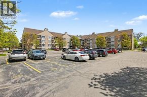 Kitchener condo for rent - A parking lot with cars and apartment buildings in the background.
