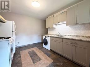 Toronto (Palmerston-Little Italy) apartment for rent - A kitchen with a white refrigerator, a washing machine, and a rug on the floor.