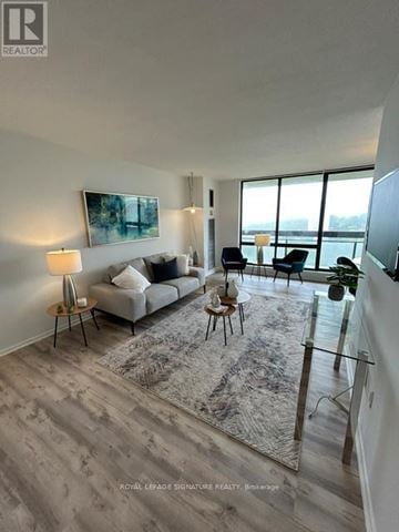 Toronto (Don Valley Village) condo for rent - A well-lit living room with a grey sofa and a glass table.