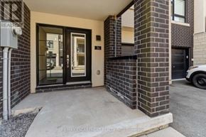 Burlington (Lasalle) townhouse for rent - The entrance to a building with a brick wall and a glass door.