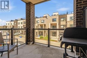 Burlington (Lasalle) townhouse for rent - A balcony of apartment buildings with a black railing and a wicker chair.