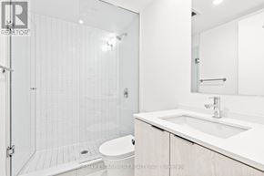Hamilton (Beasley) condo for rent - A white bathroom with a walk in shower and toilet.