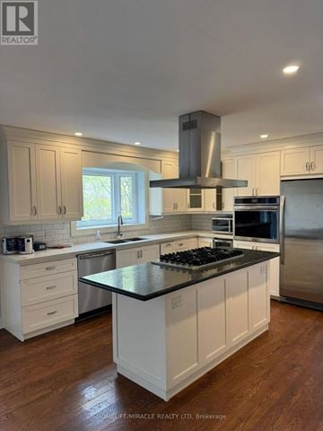 Caledon (Palgrave) apartment for rent - A modern kitchen with white cabinets and a black countertop.
