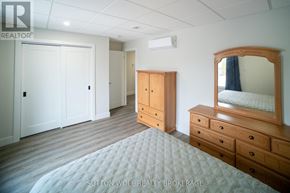 Strathroy-Caradoc (Nw) multi-family for rent - A bedroom with a bed, dresser, and wardrobe.