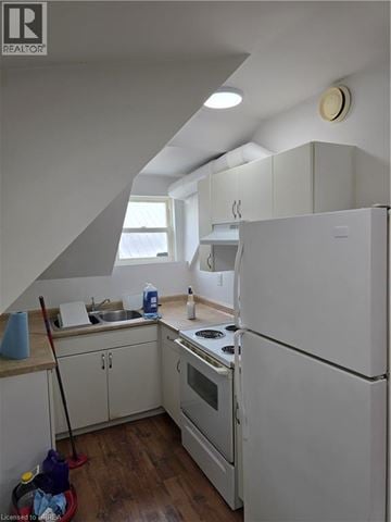 Brantford apartment for rent - A kitchen with white appliances and wooden floors.