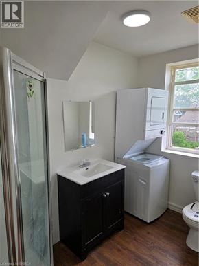 Brantford apartment for rent - A bathroom with a toilet, sink, and a window.