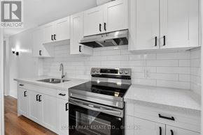 Niagara-On-The-Lake (Town) apartment for rent - A modern kitchen with white cabinets and a stainless steel stove.