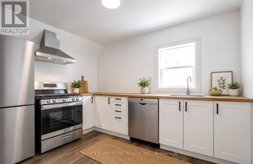 Hamilton (Stipley) apartment for rent - A kitchen with white cabinets and a stainless steel refrigerator.