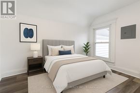 Hamilton (Stipley) apartment for rent - A bedroom with a large bed and a nightstand with a lamp.