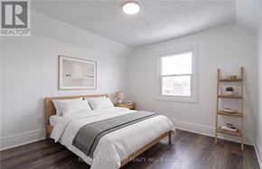 Hamilton (Stipley) apartment for rent - A bedroom with a bed, nightstand, and a window.