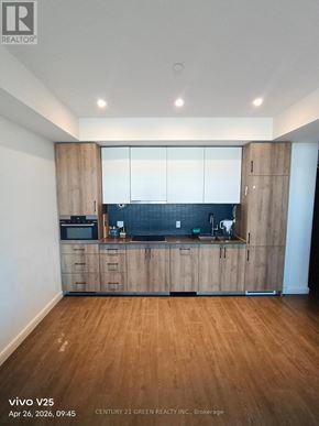 Kitchener condo for rent - A kitchen with wooden cabinets and a countertop.
