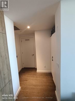 Kitchener condo for rent - A hallway with a door and a wall-mounted TV.